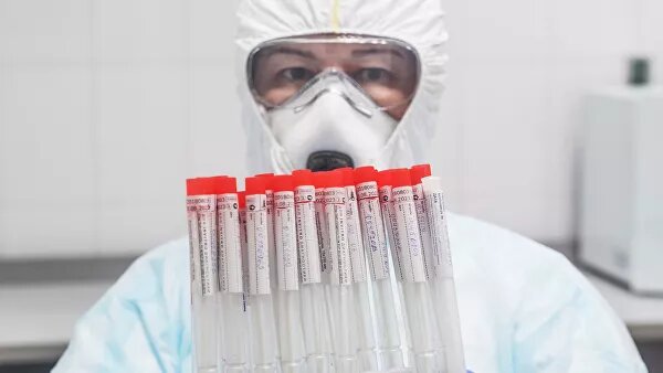   Лаборант держит в руках пробирки с биоматериалом для тестирования на коронавирусную инфекцию. Архивное фото