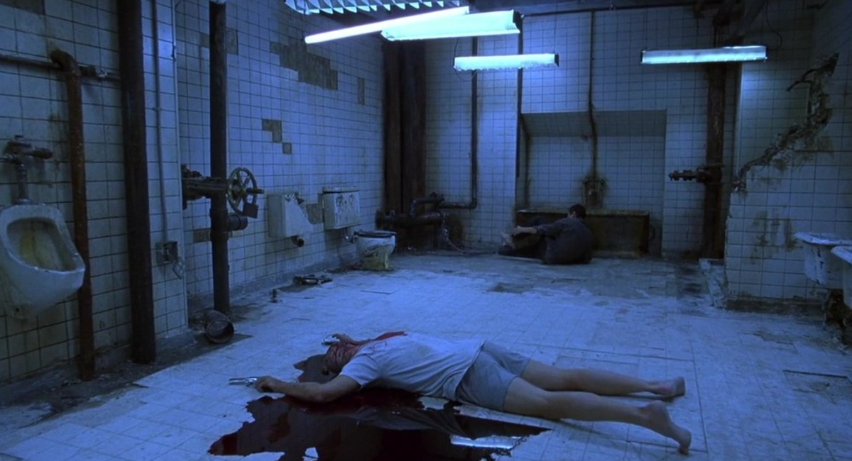 к/ф «Пила: Игра на выживание» 2004 г. Джон Крамер(Тобин Белл) лежит на полу в луже крови