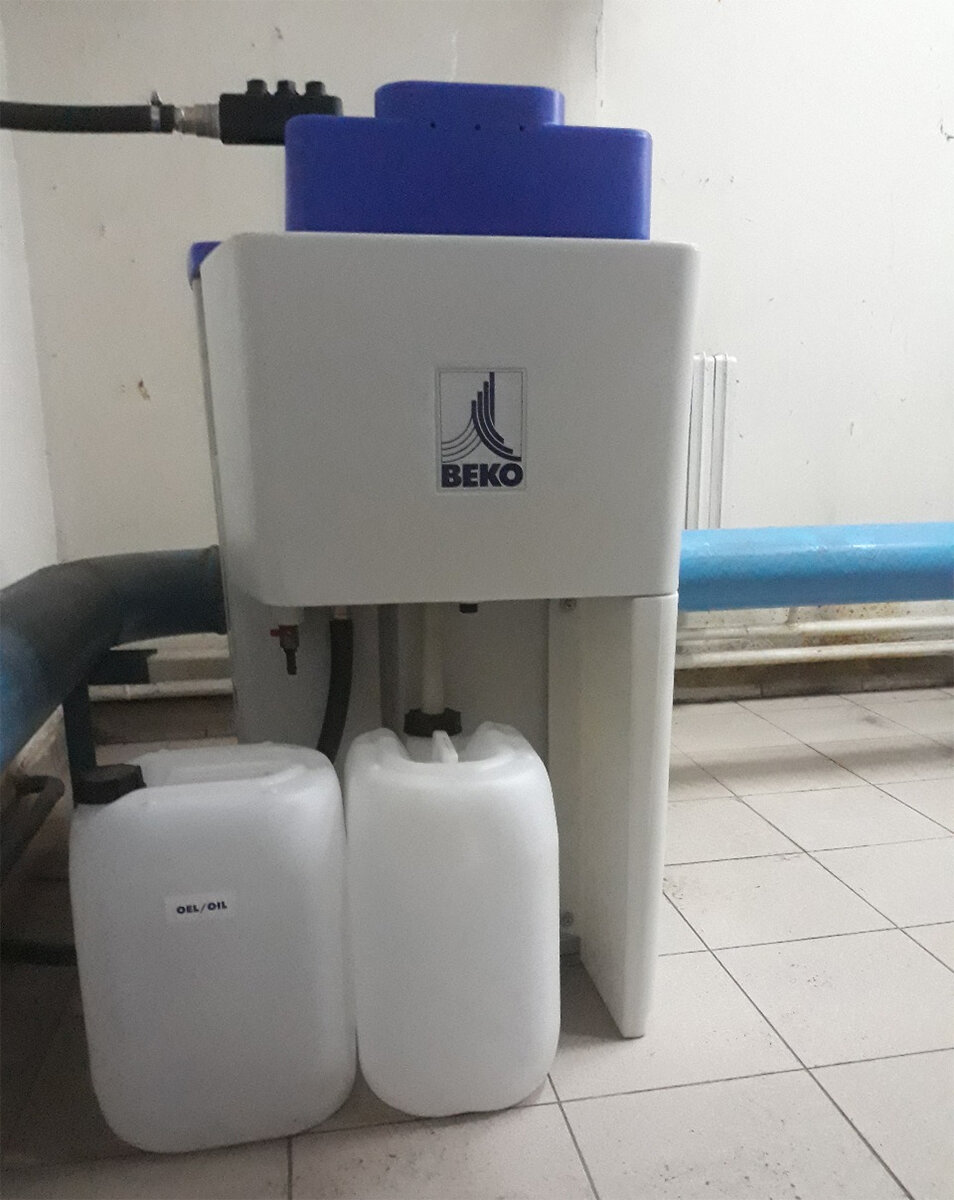 Водо-масляный сепаратор OWAMAT производства немецкой компании BEKO Technologies, установленный на производстве, с канистрами для сбора вредных масляных примесей, которые подлезат специальной утилизации.