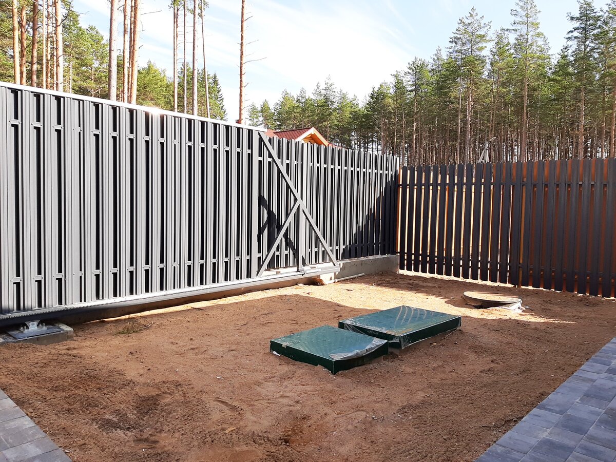 Часть забора, выходящая на дорогу обшита штакетником с двух сторон