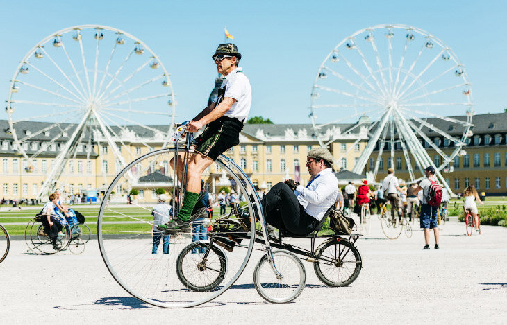 200 лет назад, в 1817 году немецкий профессор барон Карл фон Дрез из Карлсруэ создал макет первого двухколёсного самоката, который он назвал «машиной для бега». Самокат Дреза был двухколёсным, снабжён рулём и выглядел в целом, как велосипед без педалей. 
Чтобы отпраздновать этот юбилей, во дворце Карлсруэ, Германия собрались любители велосипедов с самыми невероятными машинами. Посмотрим на самые необычные велосипеды и узнайте интересные факты о них. Само слово «Велосипед», появилось в 1860 году, во Франции, Пьер Мишо (человек, придумавший термин «велосипед») хотел подобрать такое слово, чтобы оно определило транспортное средство на двух колесах с простым механическим приводом. На французском слово звучит – BICYCLETTE (Би Секлетте). 
1. Производство велосипедов сыграло большую роль в создании технической базы для других видов транспорта, прежде всего автомобилей и самолётов. Многие технологии металлообработки, разработанные для производства как велосипедных рам, так и других частей велосипедов (шайб, подшипников, зубчатых колёс), впоследствии использовались в производстве автомобилей и самолётов. (Фото Alexander Scheuber): 2. Многие автомобильные фирмы, созданные в начале XX века (например, Rover, Шкода, Опель), начинали как велосипедные. (Фото Alexander Scheuber): 3. Пенни-фартинг — один из ранних типов велосипеда, характеризующийся очень большим передним и маленьким задним колесом, который получил распространение в 1880-х годах. (Фото Alexander Scheuber): 4. Для того, чтобы двухколёсный велосипед не упал, нужно постоянно поддерживать равновесие. Поскольку его площадь опоры — это две точки, в которых колеса касаются земли, велосипед может находиться только в динамическом (неустойчивом) равновесии. Это достигается с помощью «подруливания»: если велосипед наклоняется, велосипедист отклоняет руль в ту же сторону. В результате передняя точка опоры смещается в сторону наклона и равновесие восстанавливается. Этот процесс происходит непрерывно, поэтому двухколёсный велосипед не может ехать строго прямо; если руль закрепить — велосипед упадёт. Чем выше скорость, тем быстрее передняя точка опоры вернется в равновесное положение и тем меньше нужно отклонять руль, чтобы поддерживать равновесие. (Фото Alexander Scheuber): 5. Первый велосипед, похожий на используемые в наши дни, назывался Rover — «Бродяга». Он был сделан в 1884 году английским изобретателем Джоном Кемпом Старли и выпускался с 1885 года. В отличие от велосипеда «пенни-фартинг», Ровер обладал цепной передачей на заднее колесо, одинаковыми по размеру колёсами, и водитель сидел между колёсами. (Фото Alexander Scheuber): 6. Первый складной велосипед сделан в 1878 году, первые алюминиевые — в 1890-х годах. (Фото Alexander Scheuber): 7. Велосипеды продолжали совершенствоваться и во второй половине XX века. В 1974 году началось массовое производство велосипедов из титана, а в 1975 — из углепластика. (Фото Alexander Scheuber): 8. Настоящий деревянный велосипед. (Фото Alexander Scheuber): 9. Детали. (Фото Alexander Scheuber): 10. Как уже говорилось, барон Карл фон Дрез создал «машину для ходьбы», или «беговел». Самокат был снабжён седлом и рулём, но не имел педалей. Т.е. что-то типа этого. (Фото Alexander Scheuber): 11. Почтовые службы многих стран используют велосипеды с конца XIX века. Так, британская почта использует велосипеды с 1880-х. Общее количество почтальонов-велосипедистов составляет 37 000 в Великобритании, 27 500 в Германии, 10 500 в Венгрии. (Фото Alexander Scheuber): 12. Еще один беговел. (Фото Alexander Scheuber) 13. Велосипед содержит трансмиссию, которая передаёт усилие от ног человека к колесу. Трансмиссия бывает нескольких видов, но в подавляющем большинстве случаев используется цепная передача. (Фото Alexander Scheuber): 14. С момента создания велосипеда производятся постоянные попытки определить предел его скорости. Так, в 1995 году на Бонневильской соляной равнине (штат Юта, США) была установлена скорость 268.83 км/ч. В 2010 году Маркус Штольц развил на велосипеде скорость 210 км/ч с горы в Чили. (Фото Alexander Scheuber): 15. Китай также является основным производителем велосипедов, в частности благодаря тому, что в последние десятилетия большинство велосипедных фирм перевели производство в эту страну. Порядка 95% велосипедов производится в Китае. (Фото Alexander Scheuber): 16. В настоящее время велосипеды наиболее популярны в странах Северной и Западной Европы. Самая «велосипедная» страна Европы — Дания, средний житель этой страны проезжает за год на велосипеде 893 километра. Следом идут Нидерланды (853 км). В Бельгии и Германии средний житель проезжает за год на велосипеде около 300 километров. (Фото Alexander Scheuber): 18. В Амстердаме (Нидерланды), называющем себя велосипедной столицей Европы, есть даже специальная гостиница для велосипедистов, Van Ostade Bicycle Hotel. Можно арендовать водный велосипед, велосипед-тандем и даже велосипед для 8 человек. (Фото Alexander Scheuber): 19. В России велосипед не пользуется особой популярность. Причин этому несколько: неразвитость велосипедной инфраструктуры (велодорожки, велостоянки и др.), перегруженность улиц мегаполиса автомобильным транспортом, неудобство хранения велосипеда в многоквартирных домах, а также отношение большей части населения к велосипеду как к «несерьёзному» виду транспорта. (Фото Alexander Scheuber): 20. В 1839—1840 годах изобретение было усовершенствовано. Шотландский кузнец Киркпатрик Макмиллан добавил к нему педали. Заднее колесо прикреплялось в педали металлическими стержнями, педаль толкала колесо, велосипедист находился между передним и задним колесом и управлял велосипедом с помощью руля, который в свою очередь был прикреплен к переднему колесу. 21. Самые дорогие велосипеды изготавливает фирма Aurumania. Они продают велосипеды, покрытые 24-каратовым золотом и 600 кристаллами Сваровски. Этот золотой велосипед «Crystal Edition» является эксклюзивным и изготовлен всего в 10 экземплярах. Стоимость этого транспортного средства оценивается в 100 000 долларов. 
Источник: https://vseznaesh.ru/samye-interesnye-fakty-o-velosipedah © ВсеЗнаешь.ру