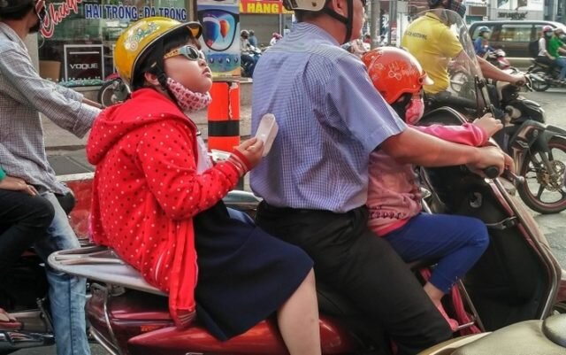  Девочка завтракает, пока отец везет ее в школу на мотоцикле 