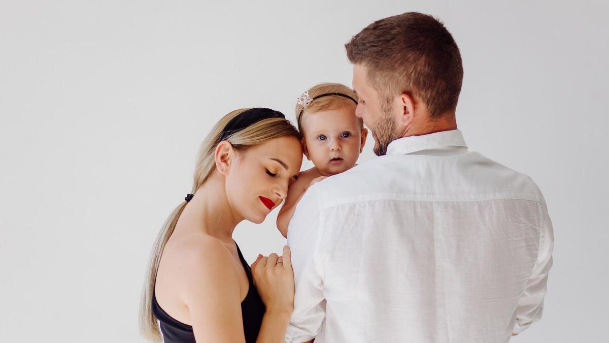    Пара держит на руках дочь:Freepik