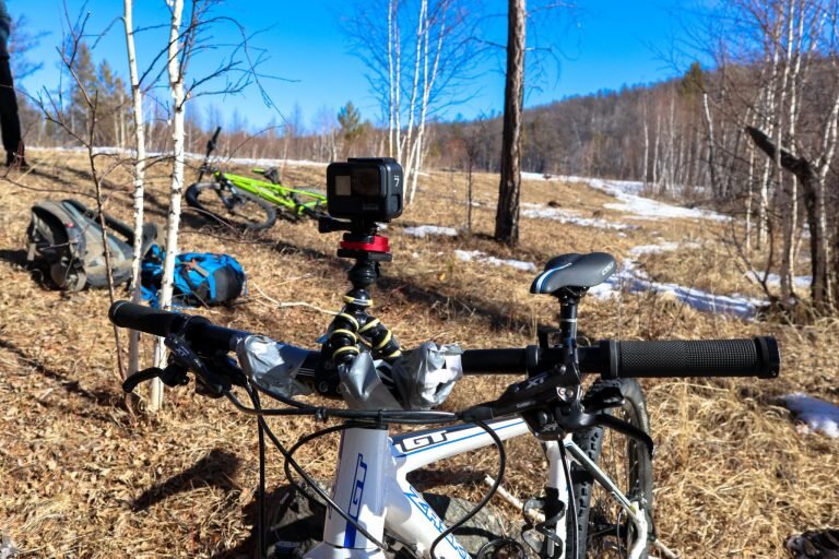 Экшн-камера GoPro 7 Black закреплена на штатив "паук" и зафиксирована армированным скотчем к рулю велосипеда.