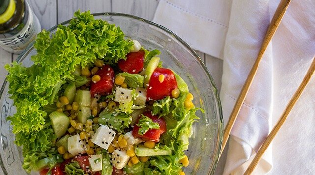 Ингредиенты:

Для салата:

пучок свежего зелёного салата
3-4 средних помидора
3 небольших огурца
100-150 гр. белого сыра (можно любой, у меня был не очень соленый, упругий сорт)
100 гр. консервированном кукурузы
несколько веточек зелёного лука
Для соуса:

3 ст. л. растительного масла (я люблю оливковое, но в этом салате можно взять любое)
2-3 ст. л. бальзамического уксуса
1 ст. л. мёда
1 долька чеснока
соль
Пошаговый рецепт:

Листья салата нарвать руками. Помидоры, огурцы и сыр нарезать небольшими кубиками, примерно по 2-3 см. Добавить консервированную кукурузу и мелко нарезанный зелёный лук.
