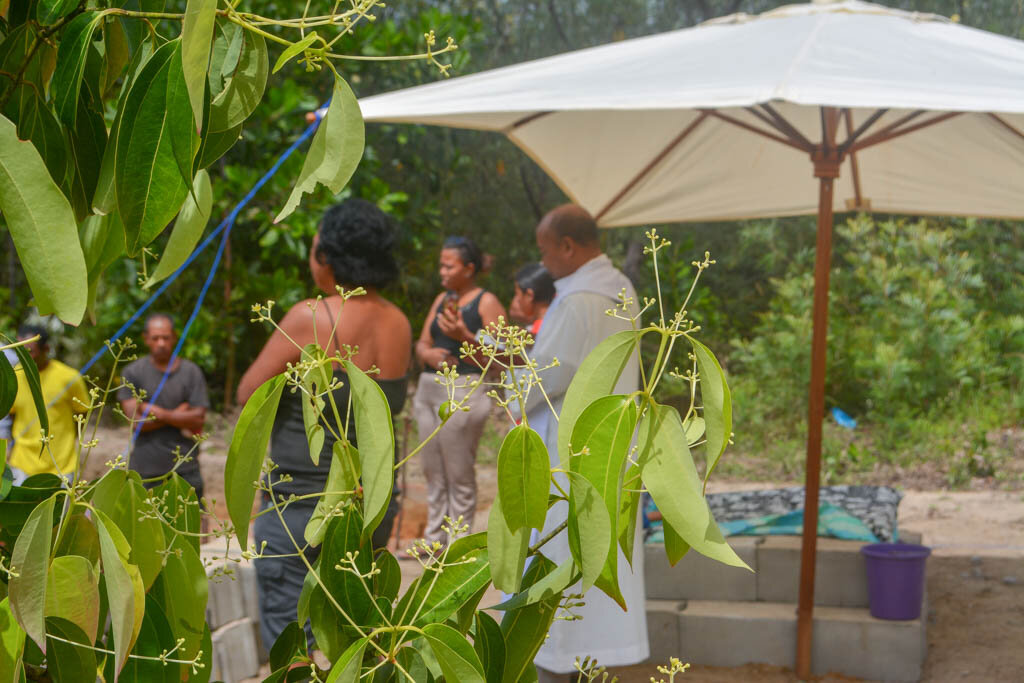 2. Утро началось с приезда местного католического священника, который освятил начало строительства дома для мамы Сандры. На переднем плане цветет корица.