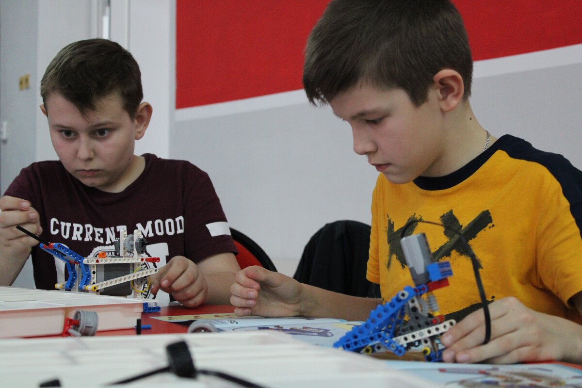 Мальчики собирают и программируют роботов