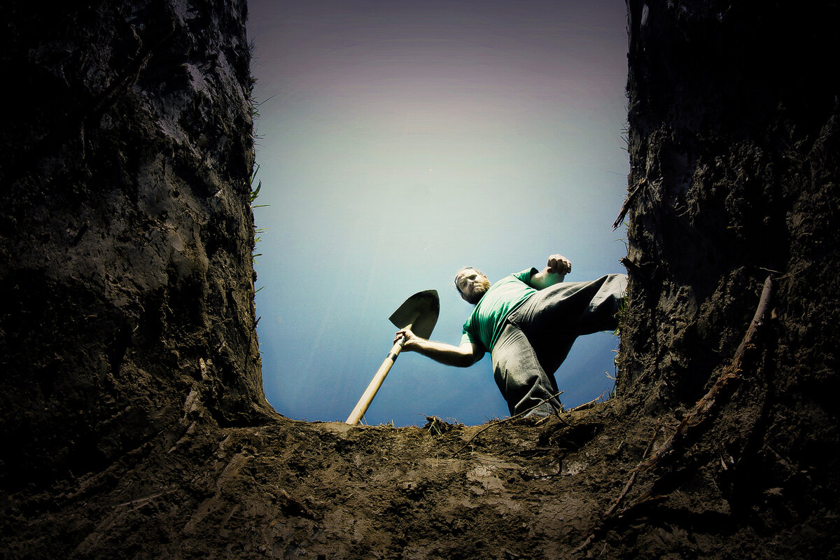 Человек копает яму