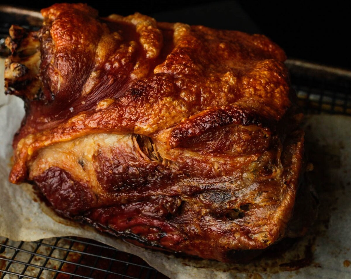 Раздвиньте вилкой нежное мясо и ультра-хрустящую кожу: запеченное свиное плечо может быть не самым великолепным на вид, но божественный аромат более чем компенсирует это.