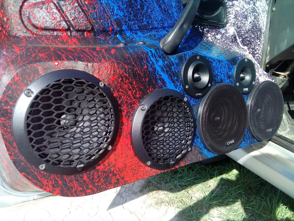 Свистящий звук в динамиках раздражает, чтобы избавиться от этой проблемы нужно разобраться в причинах и устранить их. 

Что может провоцировать:

1. Магнитола (Головное устройство, оно же ГУ).

1.1. Достань магнитолу
1.2. Если Pioneer — попробуй тонким проводом замкнуть корпус ГУ и внешнюю "юбку" RCA-разъема. Если фон пропадет — неси ГУ в сервис (менять сгоревший предохранитель линейных выходов). И больше не "перетыкай" межблоки при включенном ГУ\усилителе. Кстати, такое возможно и при кратковременном КЗ выходов усилителя.
1.3. Проверь надежность подключения DIN-разъема (и вообще всех разъемов ГУ).
1.4. Попробуй отключить антенну.
1.5. Проложи любым подходящим проводом плюс и минус на ГУ с аккумулятора напрямую.
1.6. Фонить и трещать на увеличении и уменьшении громкости, может от плохого контакта питания (и плюсового и массы).

2. Усилитель (и).

2.1. Попробуй поменять местоположение усилителя (лучше всего вытащить его за пределы салона). Например, усилитель в багажнике может ловить фон от бензонасоса\его проводки. Перенос на другую сторону багажника поможет убрал фон. 
2.2. Попробуй выкрутить гейн "в ноль" — фон остается? Становится тише или нет?
2.3. Корпус усилка с массой кузова соприкасается? Так нельзя, переделывай.
2.4. Отключи провод ГУ-REMOTE от усилителя и вместо него кинь "+12В" любым подходящим проводом.
2.5 Экран межблоков (хвостики).:
2.5.1 При наличии одного хвостика в межблоке (тоненькая такая жилка), он должен быть замкнут на массу ГУ (не усилителя!).
2.5.2 Хвостики экрана (не земля!), идущие из межблочных кабелей заминусуй в места минусов всех усилителей.
2.6. Если немного шатается RCA-разъем усилителя — возможно плохой контакт, необходима пропайки разъемов изнутри усилителя.

3. Межблочные кабели.

3.1. В первую очередь — перепроложить другие межблоки по воздуху, лучше вне салона машины.
3.2. Если нет возможности — отключить их от ГУ и усилителя и прозванивать на предмет обрыва\плохого контакта\КЗ с кузовом.
Потом менять положение, слушать фон и перекладывать.

4. Кроссоверы.
4.1. Попробовать переместить кроссоверы в другое место (лучше перемещать и слушать изменения в фоне).

5. Динамики и акустические провода.
5.1. Прозвонить каждый провод на предмет замыкания с массой кузова.

6. Доп. оборудование.
6.1. Наводки бывают от ксенона, парктроников и прочего доп. оборудования.

7. Питание системы в целом.

7.1. Все земли должны быть сведены в одну точку, иначе будет земляная петля. Прокинь массу ГУ к массе усилителей.
7.2. Устрани контакт ВСЕХ! компонентов (без исключения!) системы с кузовом авто, то бишь с МАССОЙ.
7.3. Подтяни клеммы на АКБ.7.4. Попробуй временно заменить АКБ.
7.5. Попробуй временно заменить свечи и высоковольтные провода.