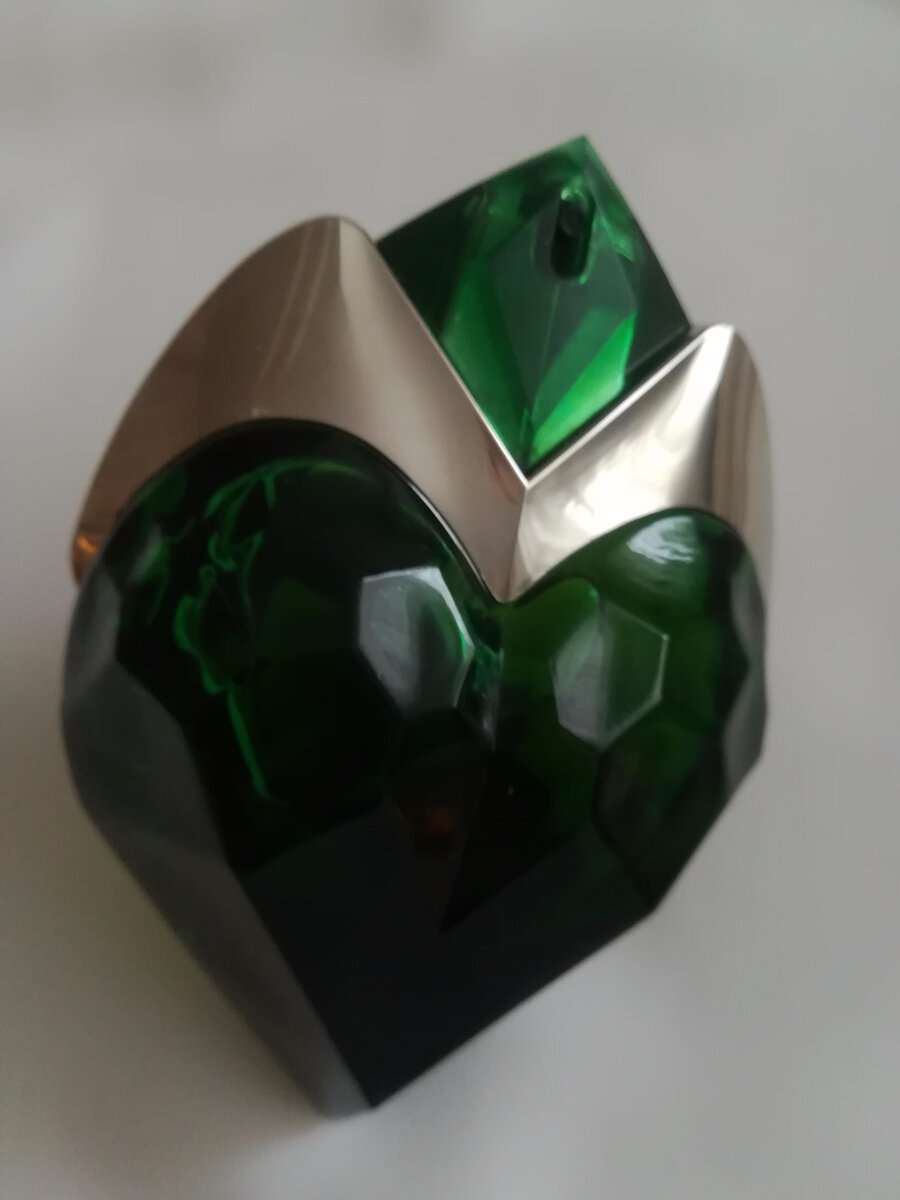 Aura MUGLER. Выпущен в 2017г. Верхние ноты: лист ревеня и бергамот; средние ноты: зеленые ноты, цветок апельсина, иланг-иланг и груша; базовые ноты: бурбонская ваниль, древесные ноты, амбервуд, сандал и кумарин.
