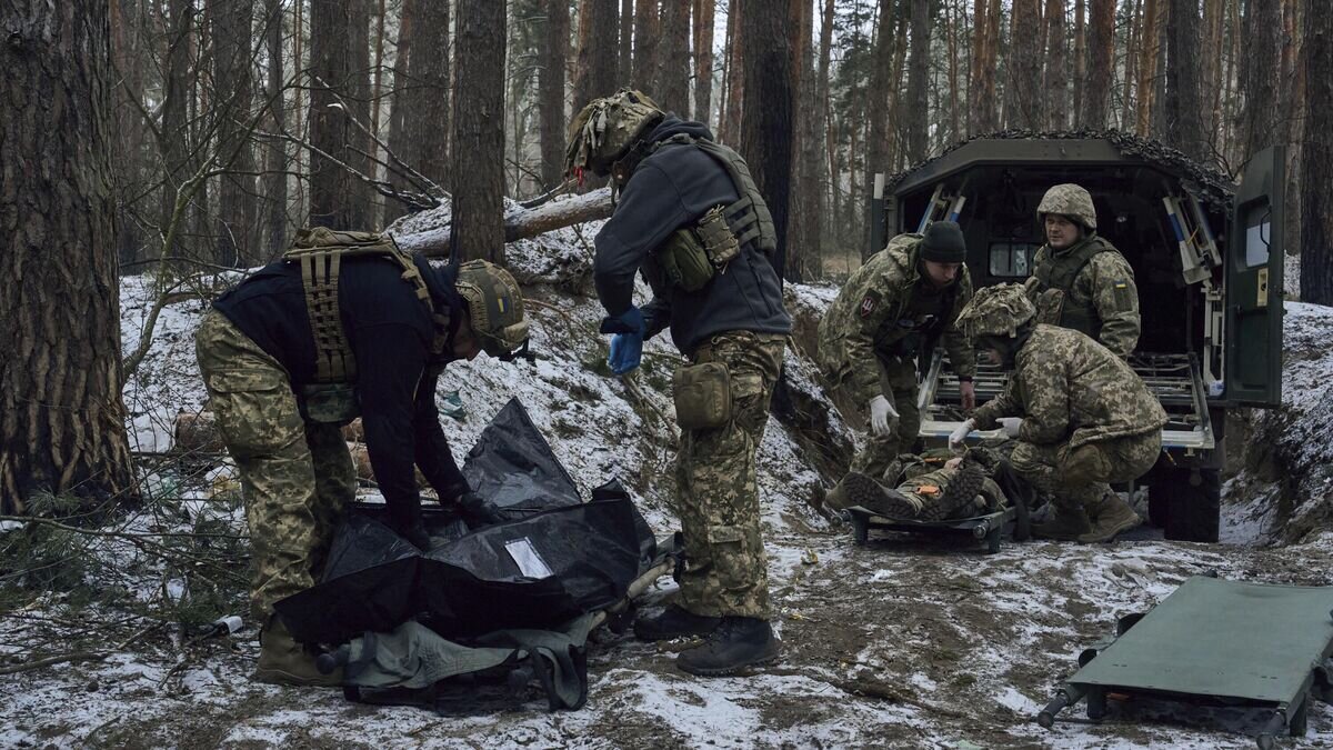    Медики помогают тяжело раненому украинскому солдату© AP Photo / LIBKOS