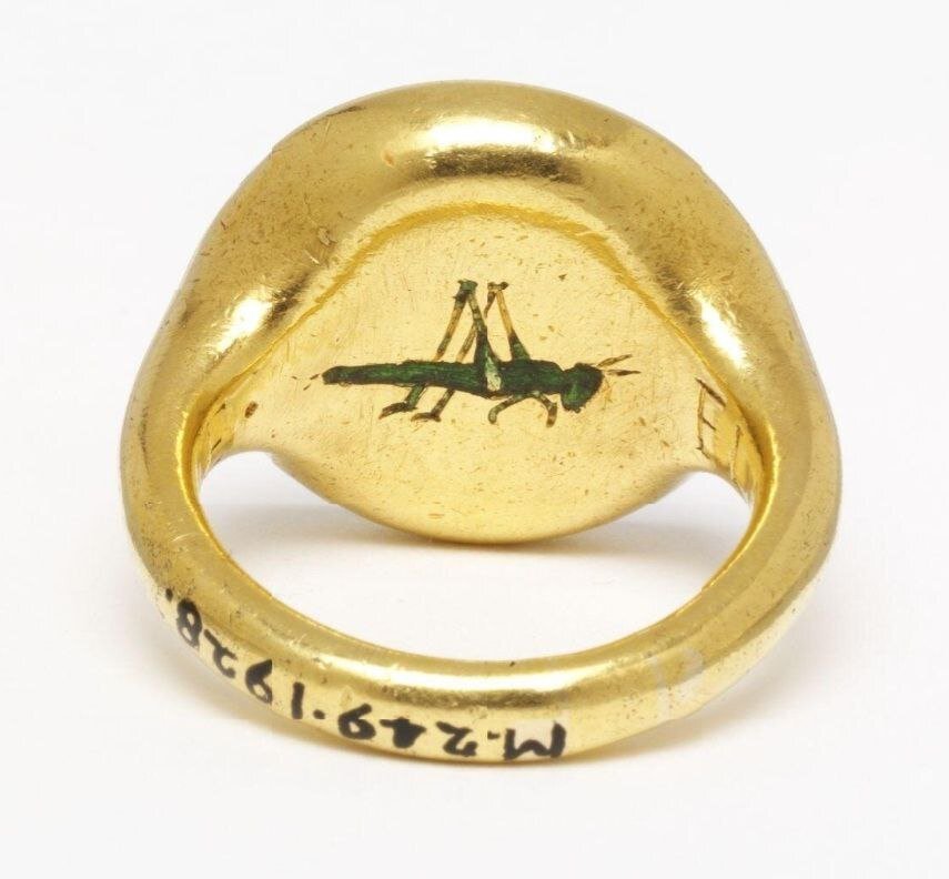 Золотое кольцо с печаткой из халцедона, с выгравированным гербом сэра Ричарда Ли и с эмалированным зеленым кузнечиком позади, значком сэра Томаса Грешама. Англия, 1544-1575 гг. Хранится в коллекции музея Виктории и Альберта.