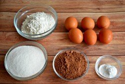 ШАГ 1:
Внутри под белково-заварным кремом прячется торт под названием "Сникерс". Для выпекания шоколадного бисквита большого торта "Сникерс" диаметром 26 сантиметров нам понадобится: 6 яиц, 240 грамм сахара, 50 грамм какао-порошка, 1 пакетик или 1,5 чайных ложек разрыхлителя для теста. Если Ваша форма для торта меньшего диаметра, 20-21 сантиметров, то количество ингредиентов нужно разделить на 1,5. Например, 6 яиц разделить на 1,5 будет 4 яйца и т.д.