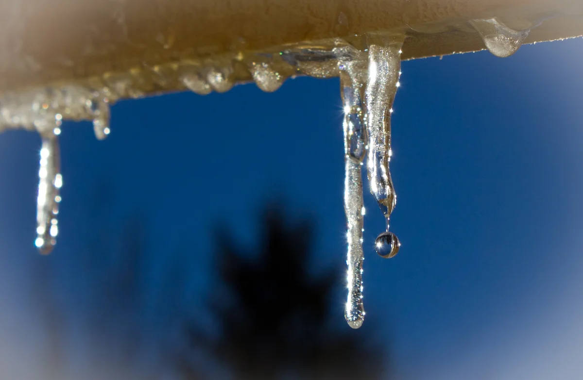 С крыш падает вода. Капель. Весенняя капель. Капель с крыши. Сосульки капель.