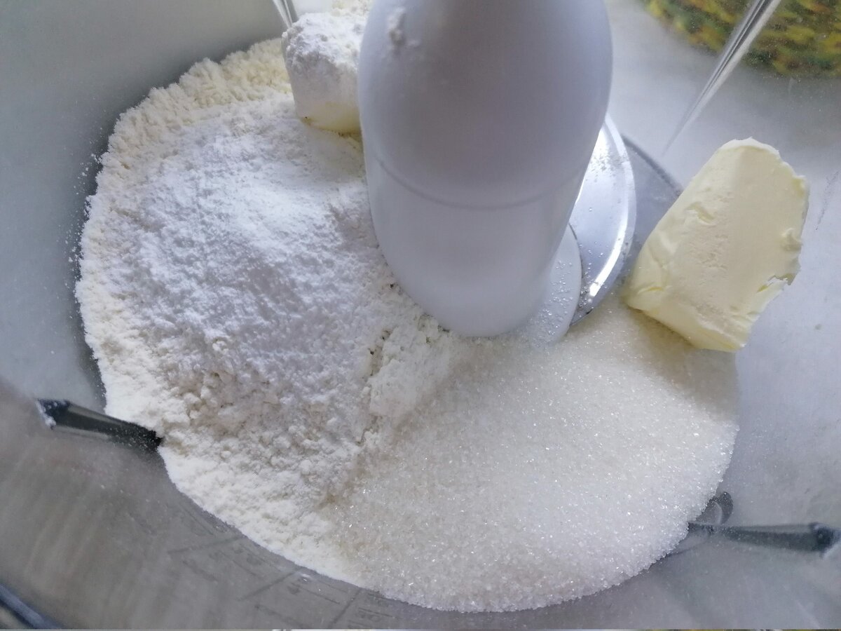 Первым делом приготовим тесто. Для этого можно использовать блендер, либо перемешивать руками. Нужно смешать муку, 100 гр. сахара, разрыхлитель и сливочное масло.