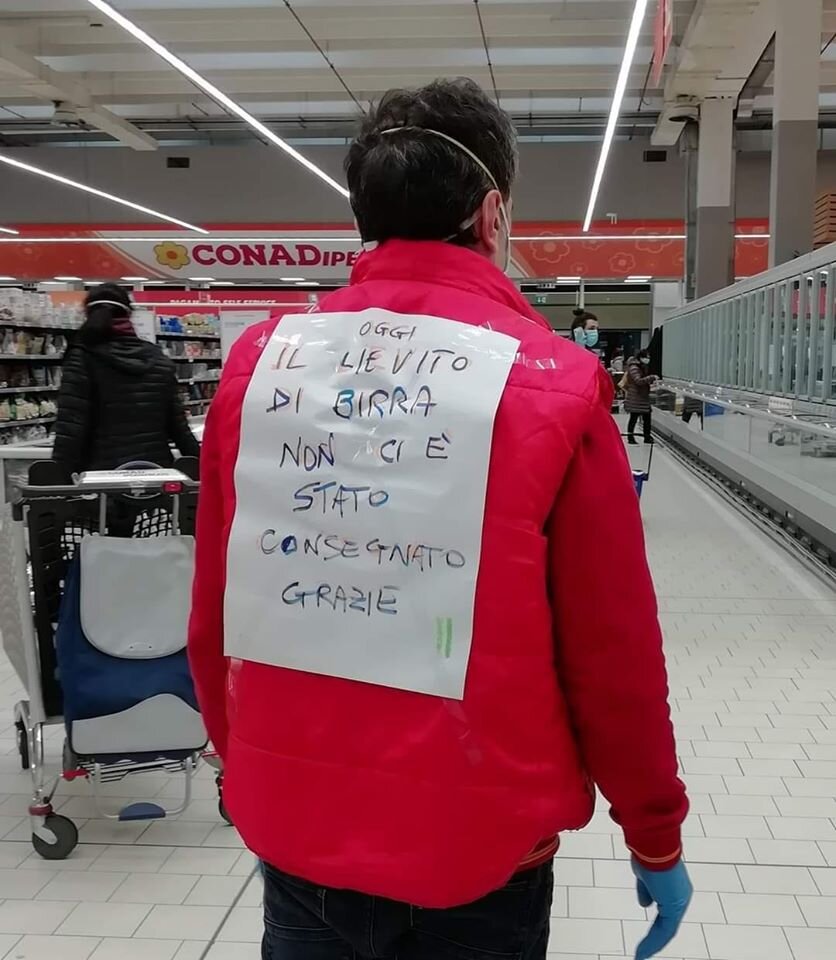 Сотрудник супермаркета с табличкой: Пивные дрожжи не завезли. Спасибо