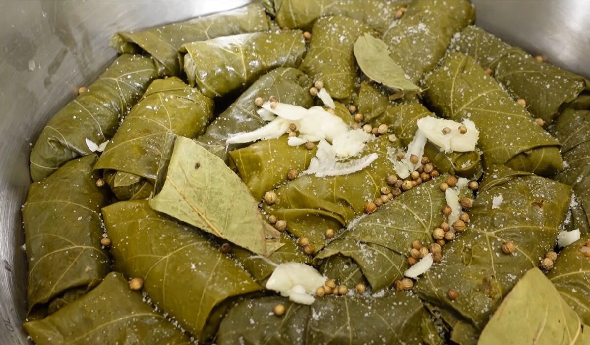 Виноградные листья, рис, фарш Митлесс “Вместо говядины”, лук, копченая паприка, черный перец, мускатный орех, хмели-сунели, свежий зеленый лук, укроп, бульон, постный майонез с чесноком и зеленью