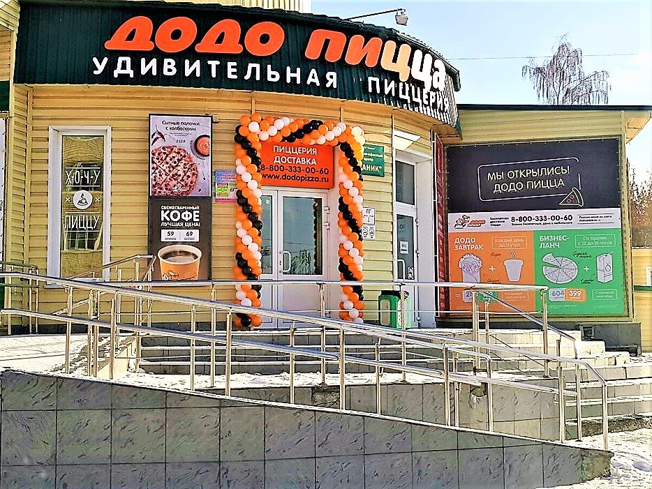 Так выглядит пиццерия с проспекта в моём городе. Расположена не особенно удобно, для тех, кто добирается на общественном,  поскольку стоит между остановками, но оптимально для тех, кто за рулём. 