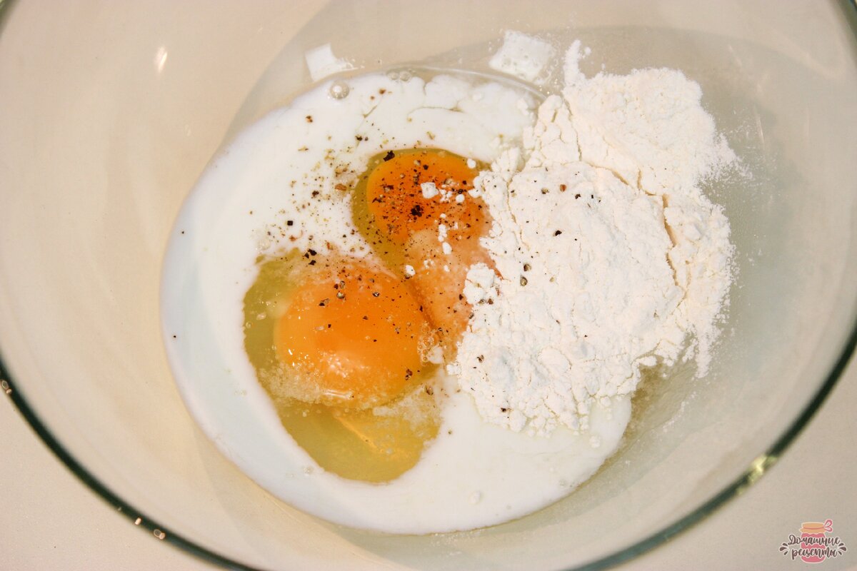 Приготовим блинчики. В чашку разбиваем яйца, добавляем молоко, немного соли и перца, добавляем муку. 