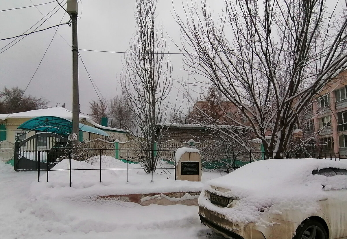 Во дворе многоэтажки - маленький домик, а рядом - постамет с табличкой