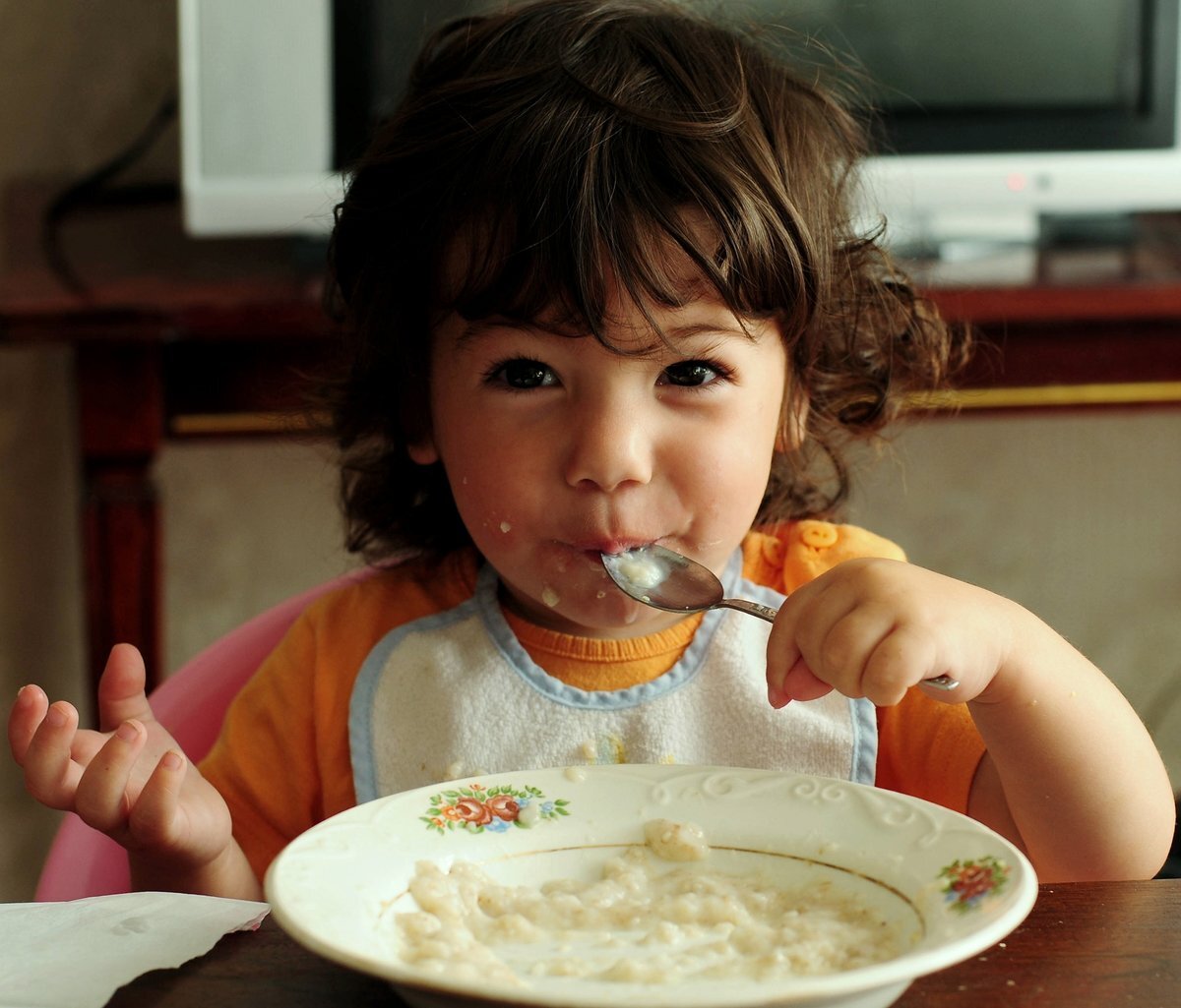 Еда для детей. Ребенок ест кашу. Ребенок завтракает. Ребенок завтракает кашей.