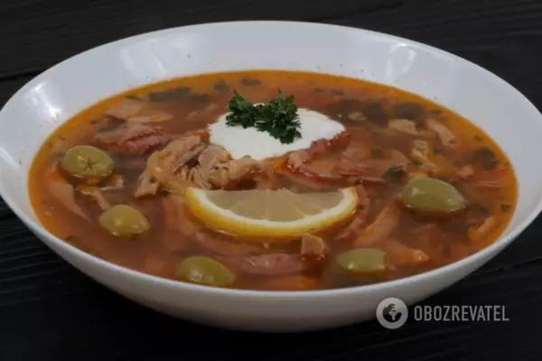 В готовую порцию солянки кладем несколько маслин, ложку сметаны и украшаем блюдо кусочком лимона