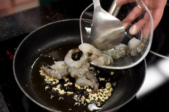 
Креветки разморозтье, обсушите бумажным полотенцем, чтобы убрать влагу.
Разогрейте на сковороде столовую ложку растительного масла. Нарежьте мелко чеснок и обжарьте в масле до запаха.
Положите креветки, посолите, полейте лимонным соком. Обжарьте в течение пары минут до готовности и пока уберите в сторону.