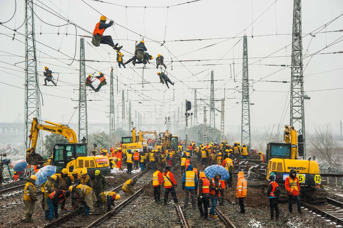 Китайские железнодорожники демонтируют старые пути и прокладывают новые.