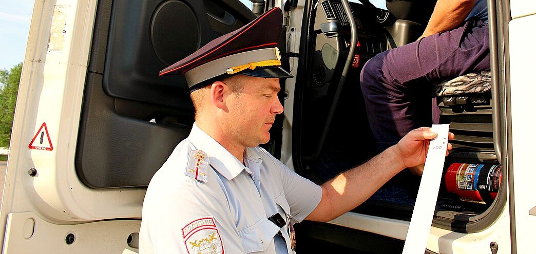 Сотрудник ДПС изучает распечатку тахографа