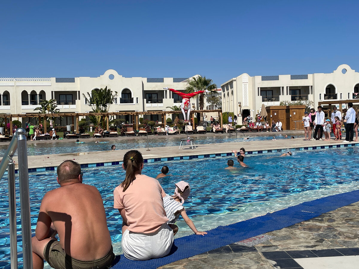 Акробатическое шоу на бассейне. Как видите, все купаются, по пальмам видно, что ветра нет. Фото автора