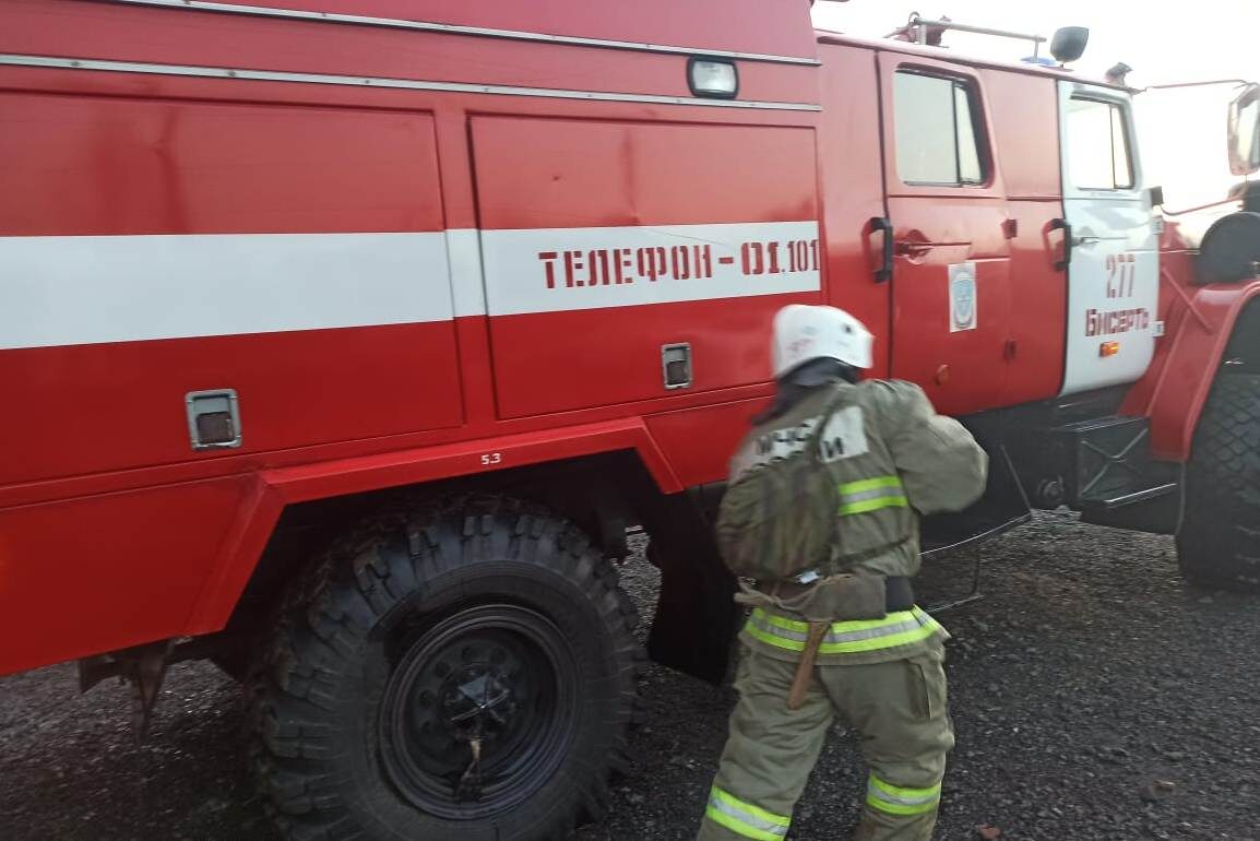 Сотрудник МЧС России и пожарная машина.