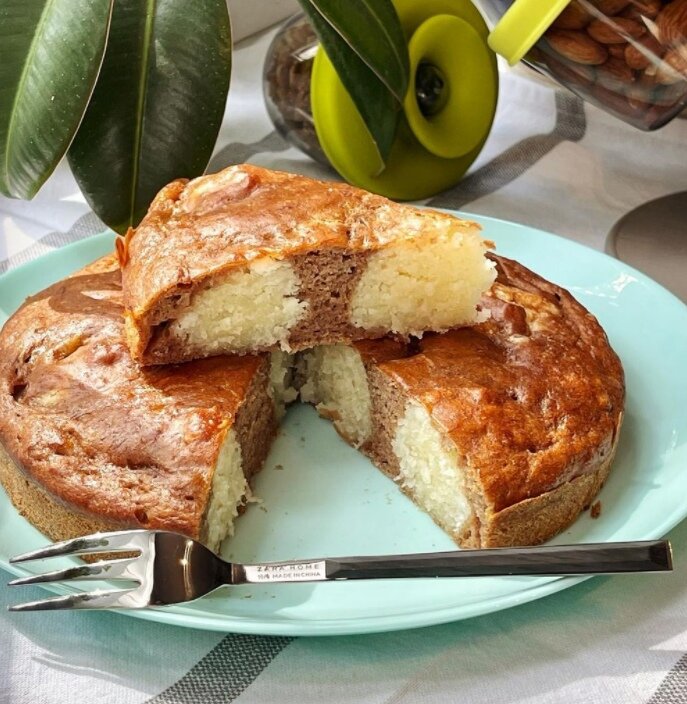 БИСКВИТ 
🟡 бананы 2 шт 
🟡 яйцо 1 шт 
🟡 сахар 70 г 
🟡 сливочное масло 30 г 
🟡 какао 1 ст.л. 
🟡 мука 3 ст.л. 
🟡 разрыхлитель 
Бананы размять вилкой. Сахар взбить с яйцом, добавить растопленное масло и перемешать. Соединить с бананом и высыпать сухие ингредиенты. Замесить жидкое тесто. 

НАЧИНКА 
🟡 творог 9% 100 г 
🟡 сахар 50 г 
🟡 кокосовая стружка 20 г 
🟡 манная крупа 2 ст.л. 
🟡 ванилин. 
Все перемешать. Слепить шарики и выложить в форму на половину теста. Залить второй половиной и выпекать 40-45 минут при 180 С°. 
Приятного аппетита😋.