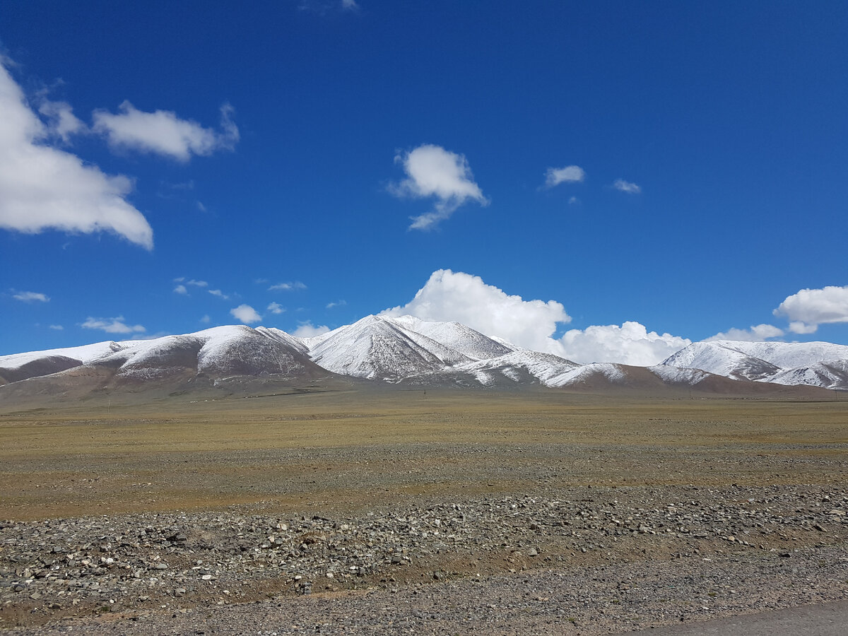 По дороге к озеру мы увидели белые шапки окружающих гор. Нам сказали, что снег тут выпал буквально вчера. Здесь чувствовался уже нешуточный, почти зимний, холод. И ветер приносил запах такой очень специфический - запах свежевыпавшего снега.