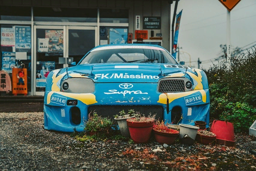 Продавцы подержанных автомобилей используют всевозможные сумасшедшие приманки, чтобы попытаться привлечь потенциальных покупателей. В США распространены гигантские надувные мужчины, которые выглядят так, словно у них диско-захват. В то время как здесь, в Великобритании, мы склонны парковать старого Фрилендера случайно на некоторых скалах. В Японии они делают все возможное — используя гниющий (и полностью подлинный) гоночный автомобиль Toyota Supra GT500 JGTC 1999 года в качестве своего рода маркетингового магнита. Как вы можете себе представить, такого рода вещи для нас — автомобильная кошачья мята. Таким образом, мы должны были проверить это для себя. Нажмите на низкую оценку этой невероятной, но очень японской истории этого зомби-гонщика.