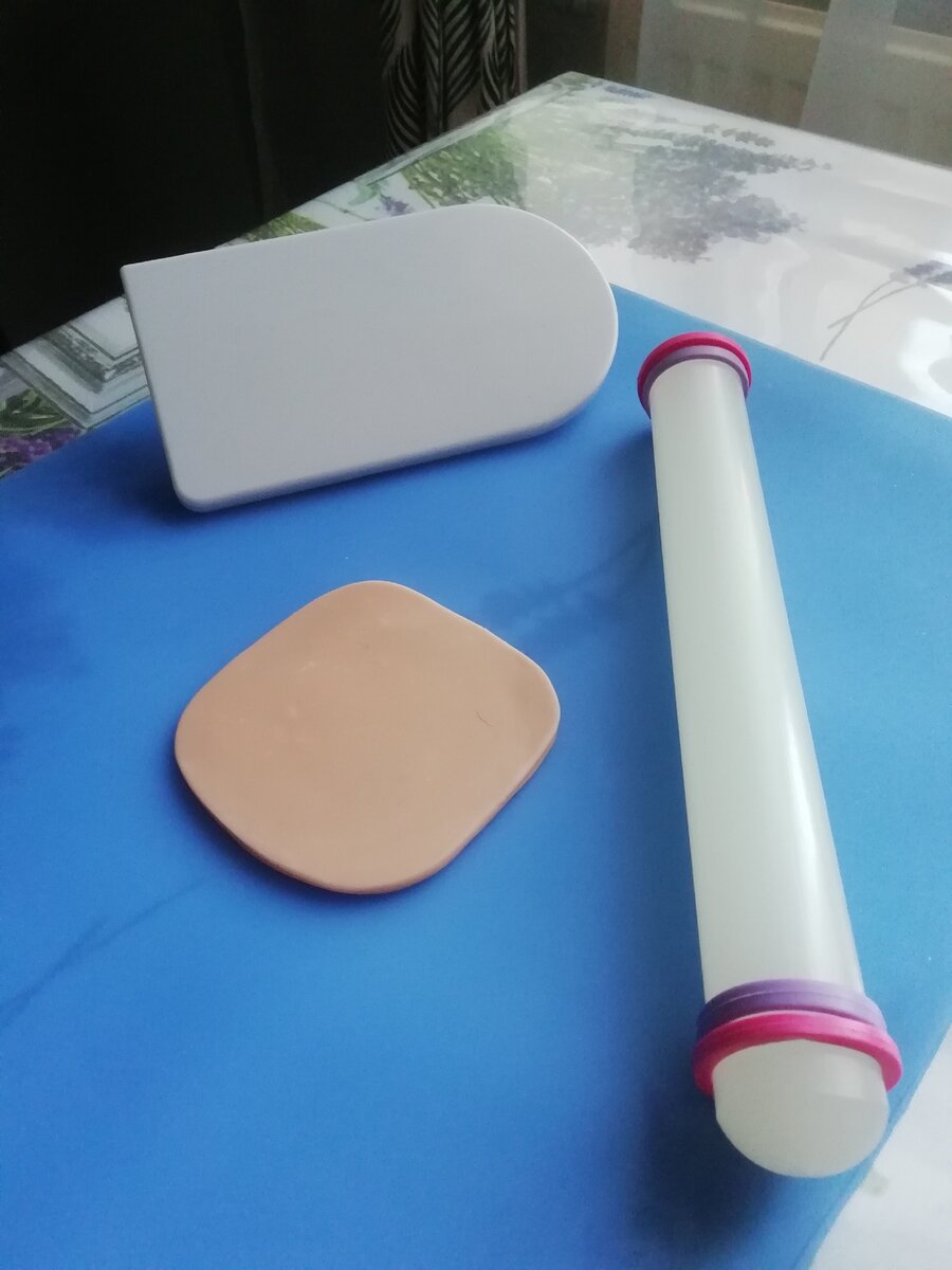 Чтобы глину легче было размять можно кусочек положить в целлофановый мешочек и опустить в кружку с горячей водой. Разминаем в руках и раскатываем скалкой. Она может быть любой, у меня для мастики (можно раскатать нужной толщины, благодаря резиновым кольцам). Хорошо, если у вас есть “Утюжок”, но если нет- не критично. 