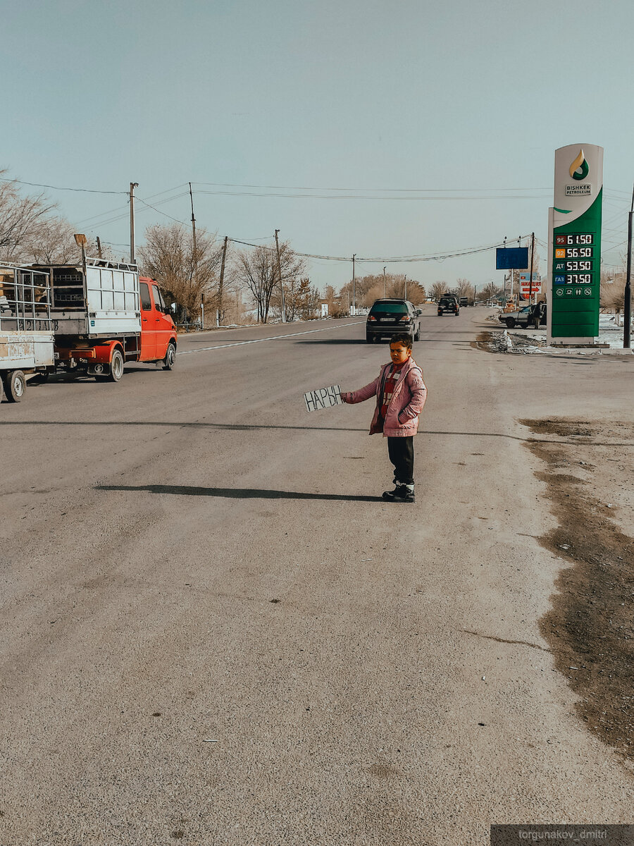 Девочка ловит попутку в Нарын, бабушка с дедушкой рядом