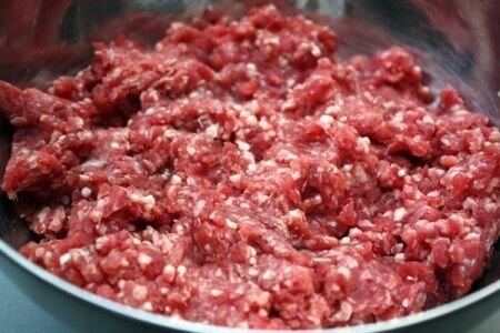     Мякоть баранины (мясо без костей) нужно хорошенько промыть в воде, затем немного обсушить. Острым ножом нарезаем мясо на небольшие куски, которые в дальнейшем мы пропускаем через мясорубку. На выходе у нас должен получиться фарш мелкого помола, поэтому либо мы устанавливаем соответствующую насадку на мясорубку, либо пропускаем его несколько раз. Далее очищаем крупную луковицу от шелухи, промываем ее и также пропускаем через лезвия мясорубки. Лучше всего пользоваться для продавливания специальным прессом, а не делать это пальцами. В получившийся фарш нужно добавить два желтка. Для этого над миской разбиваем ножом яйцо, но не раскрываем его полностью. Через образовавшуюся щель начнет стекать белок, а желток останется в скорлупе. Далее фарш немного солим и перчим и тщательно его вымешиваем до однородного состояния.   