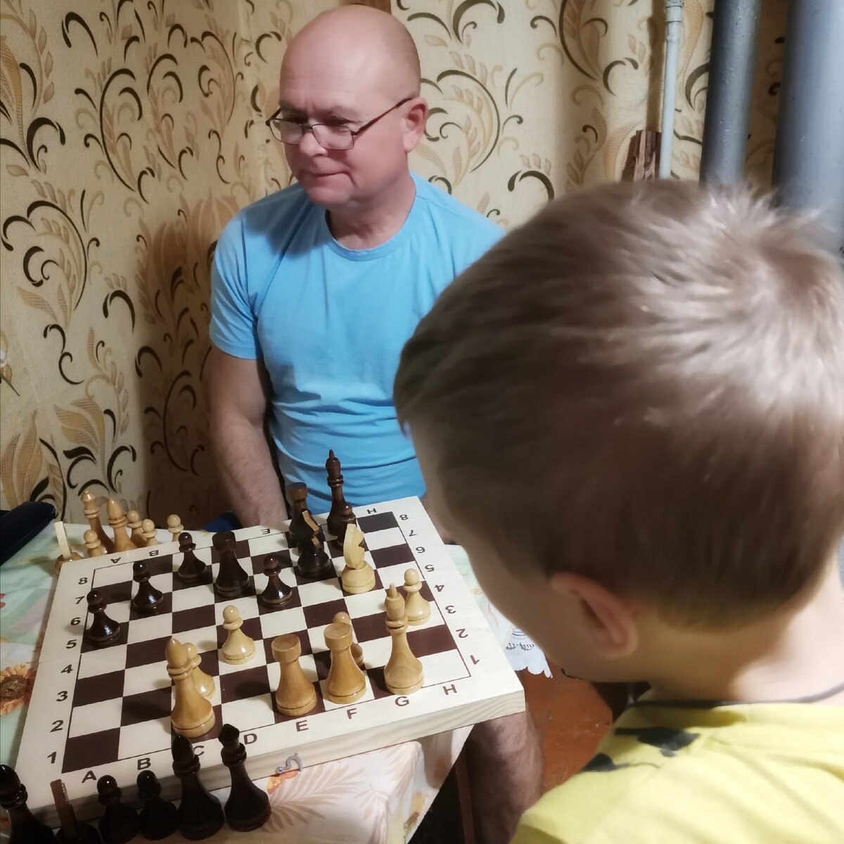 Муж и старший сын проводят совместное время за шахматами