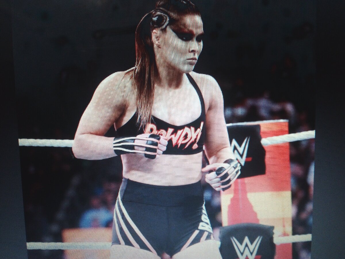 Ронда Роузи в боевой раскраске  рестлерши на ринге .