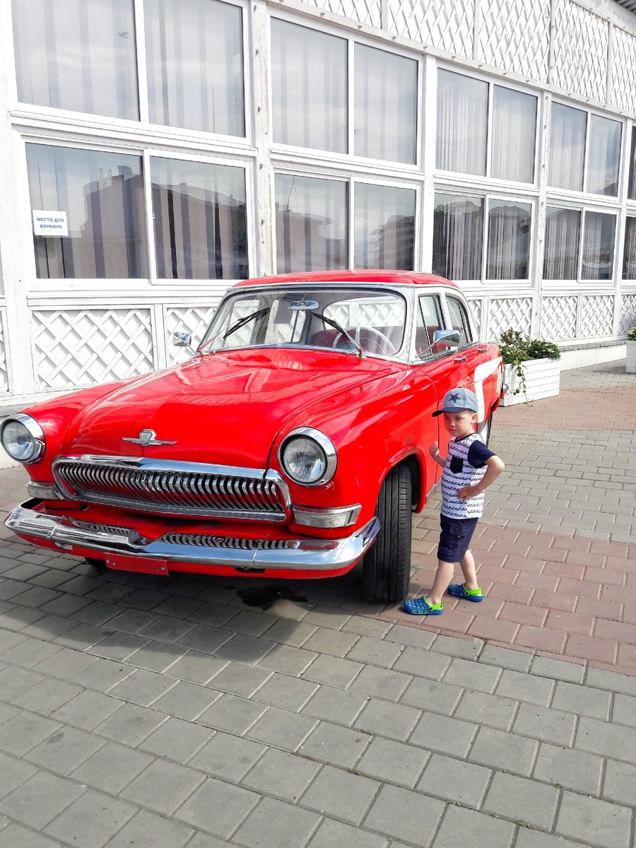 На фото советский автомобиль и современный ребенок