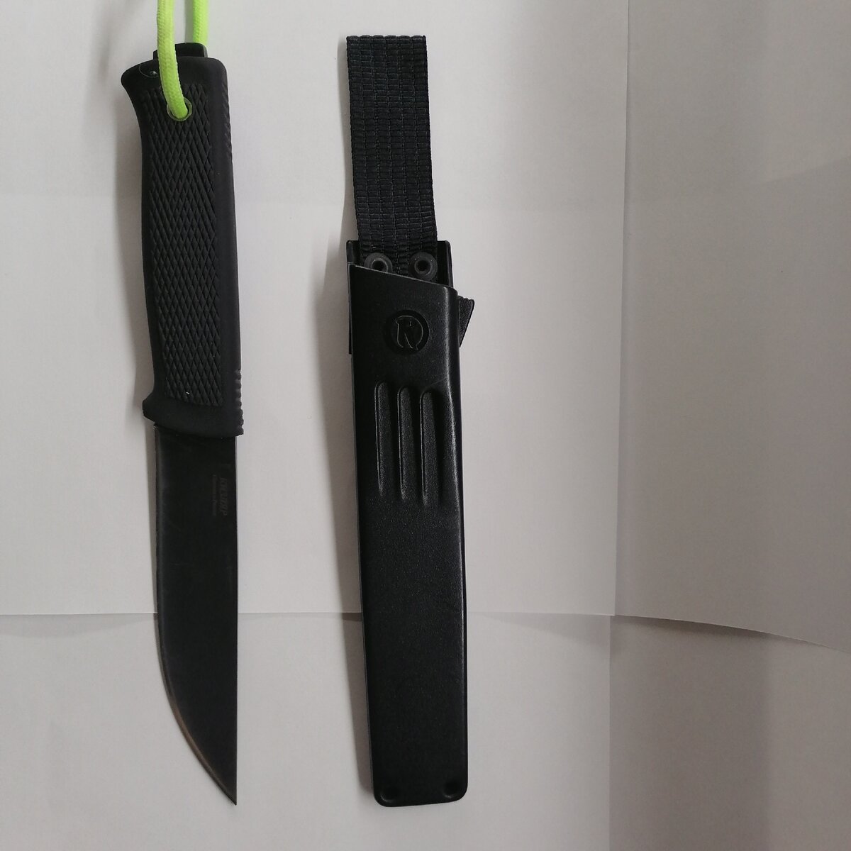 Вид ножа с разных сторон, виден темляк сделанный из флуоресцентного паракорда для удобства поиска в темноте.