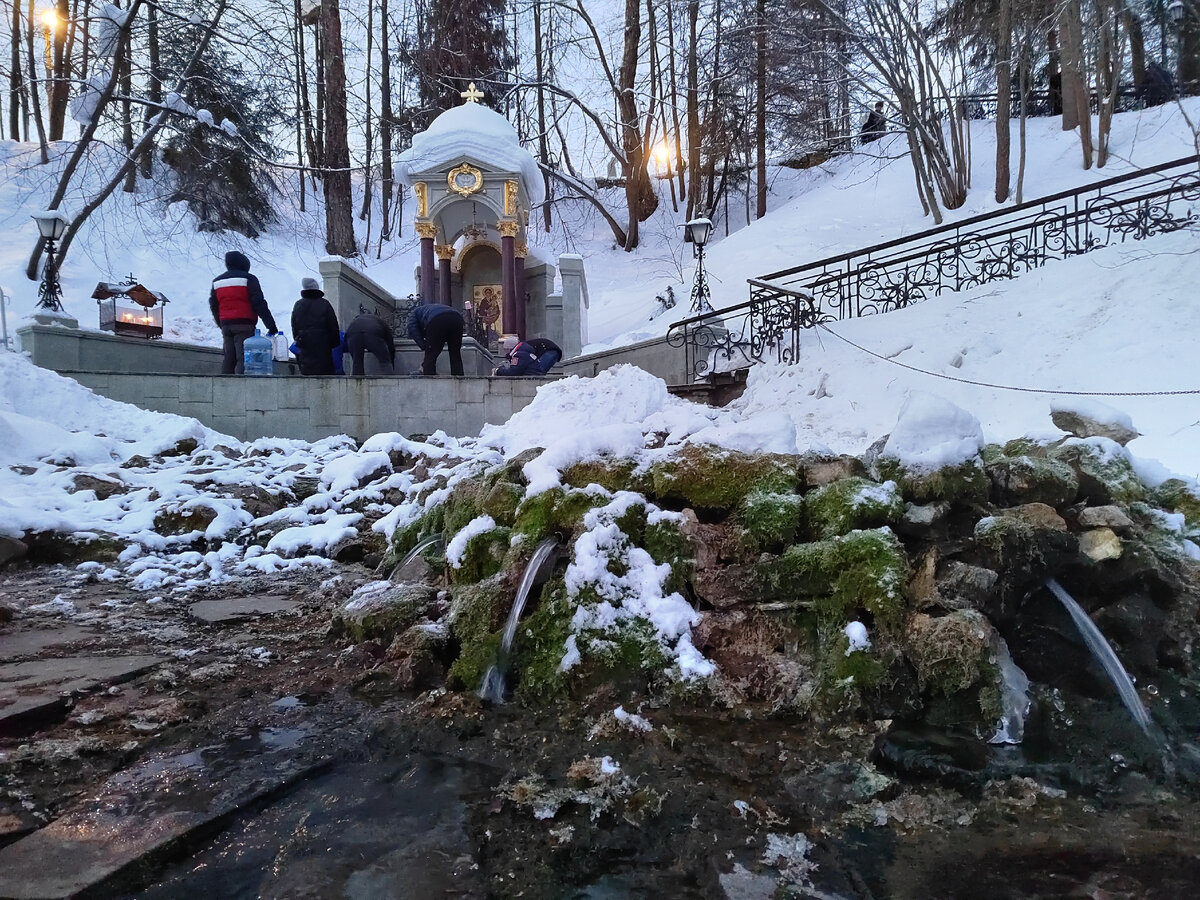 Святой источник, люди набирают святую воду. 