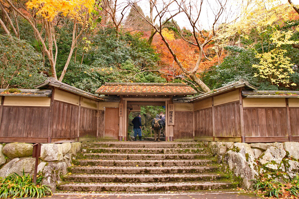 Поднимитесь по широким ступеням лестницы, минуя каменный мост, ступайте сквозь узкие традиционные храмовые врата,