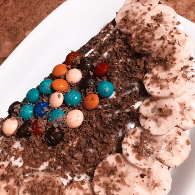 украсили тортик тёртым шоколадом, бананом и конфетками