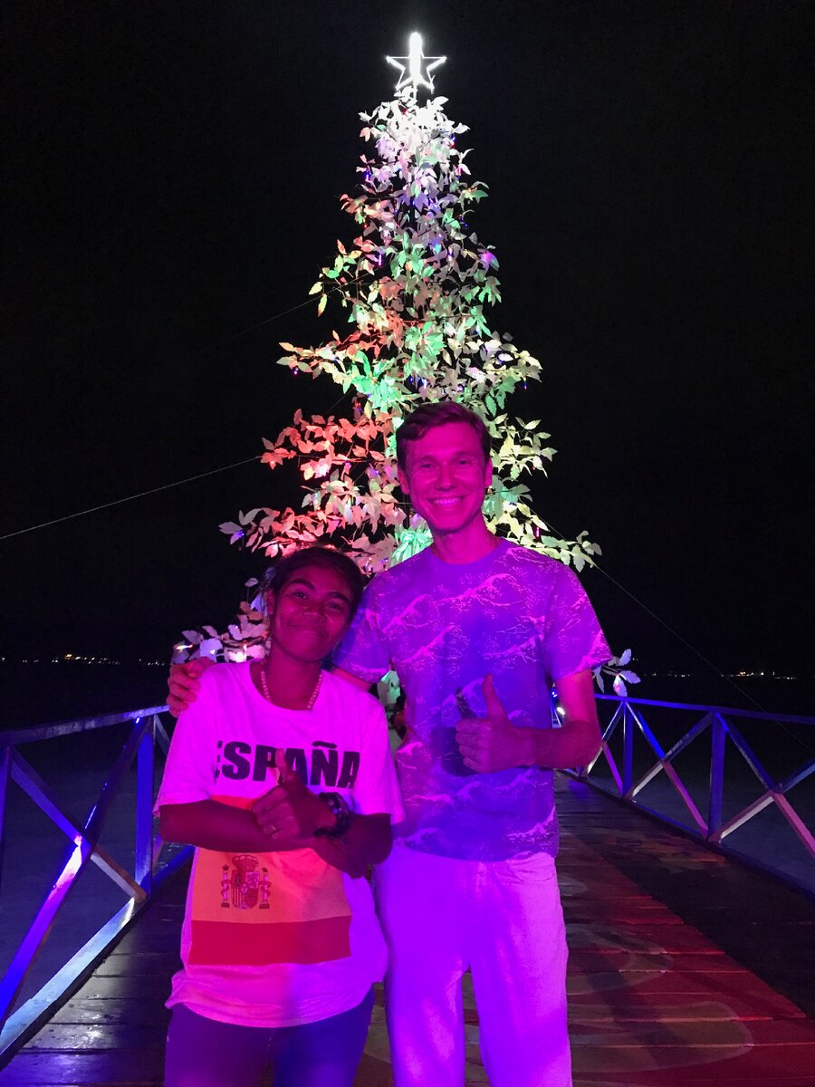 На фоне новогодней елки на берегу залива при отеле, где я жил. Амбон. Фото автора.