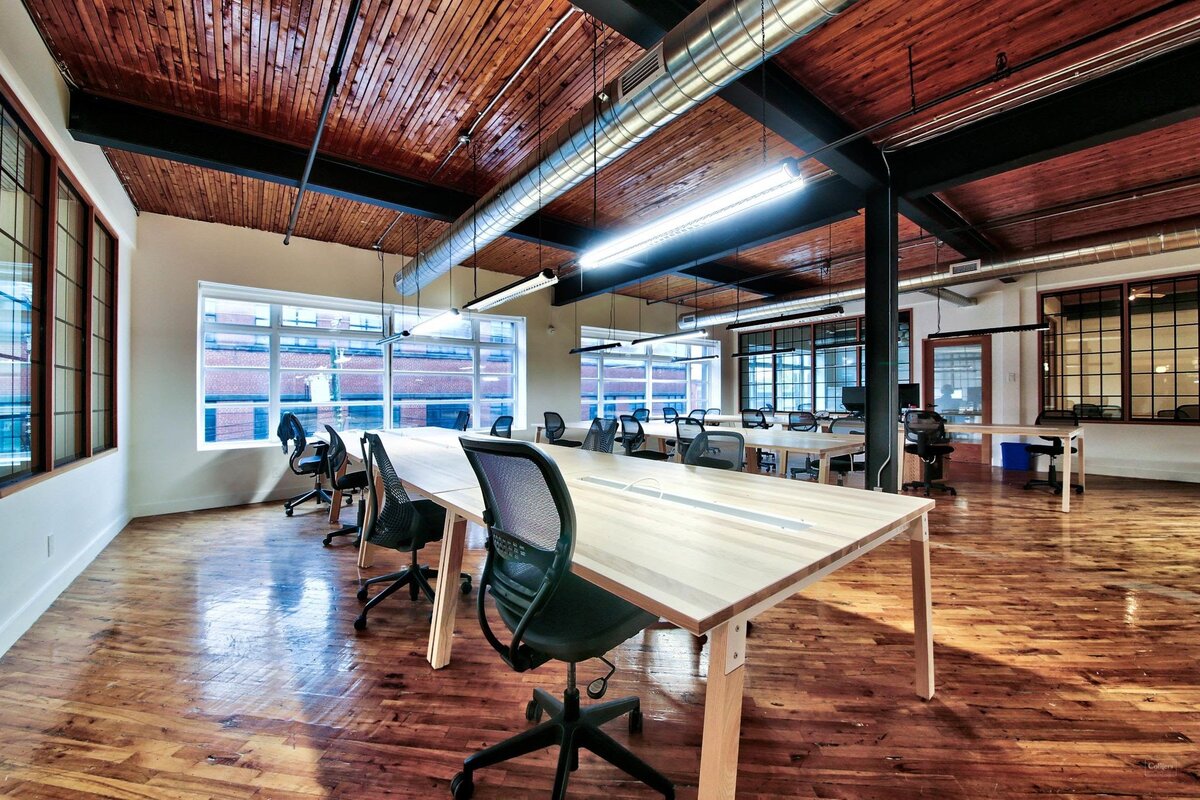 На потолке сохранены металлические балки, проведено освещение. Пол – паркет, огромные, на всю стену, окна выходят на промышленное здание. Цветы, яркие элементы отсутствуют. Источник: collierscanada.com