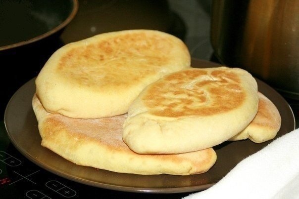 Ингредиенты: 
 
1 стакан кефира 
1 ч.л. соды и уксус для гашения 
0,5 ч.л. соли 
0,5 ч.л. сахара 
мука 
1 пачка творога 
кусочек сыра 
2 зубчика чеснока 
 
Приготовление: 
1. В кефир кладем сахар, соль и гасим уксусом соду, перемешиваем. 
2. Добавляем муку в кефир так, чтобы получилось некрутое тесто, и вымешиваем его. Скатать тесто в шар, накрыть пленкой или чашкой и дать постоять полчаса. 
Затем тесто разделить на 4 части, раскатать тонкие лепешки. 
3. Готовим начинку: 
Творог посолить, добавить натертый сыр и раздавленный чеснок, всё перемешать. 
4. Начинку выложить в центр лепешек и защипать, как пирожки. Расплющить их немного. 
5. Жарить на сухой сковороде с толстым дном на среднем огне минут по 7-10 с каждой стороны до золотистого цвета!