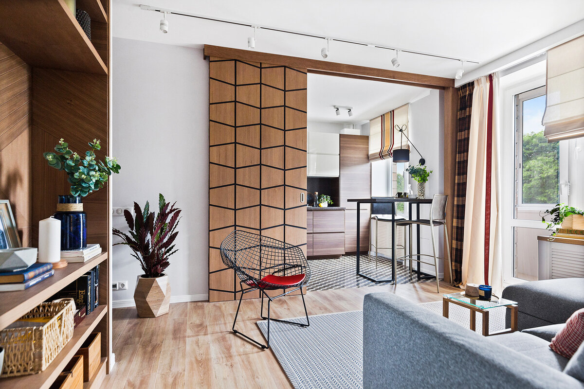 Чтобы согласовать присоединение газифицированной кухни, пришлось установить между ней и гостиной откатную перегородку. Благодаря геометричной фрезеровке она больше напоминает панно.