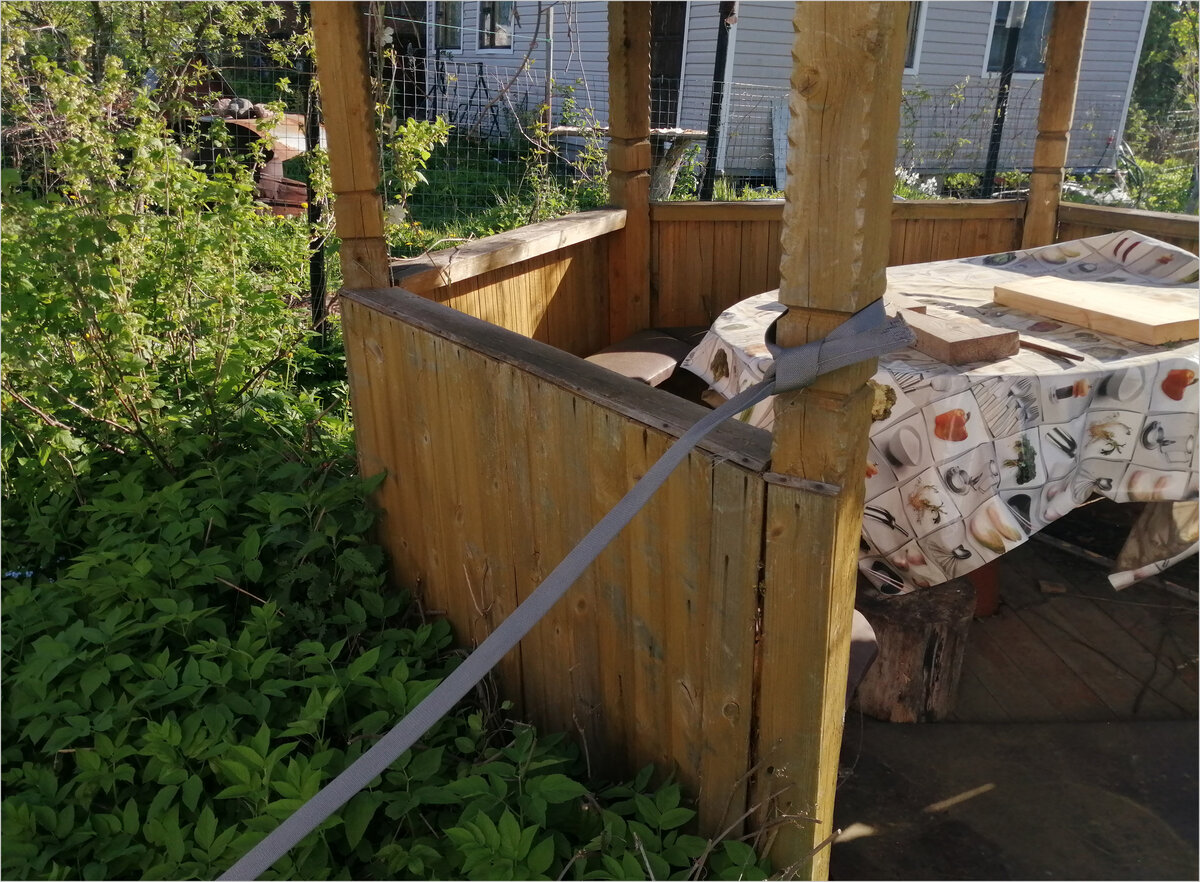 Привязываю трос к столбам беседки.